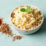 Colorful jars of spice blends beside steaming couscous with herbs and lemon